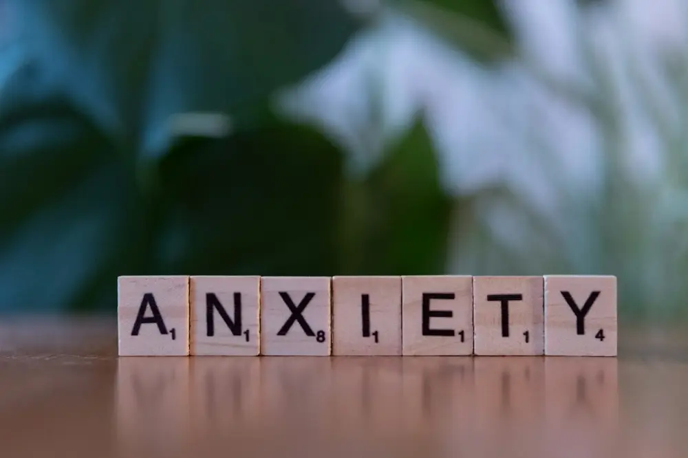 A wooden block spelling the word anxiety on a table