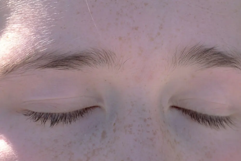 A close up of a person's eyes with freckled hair, illustrating recognizing everyday emotions